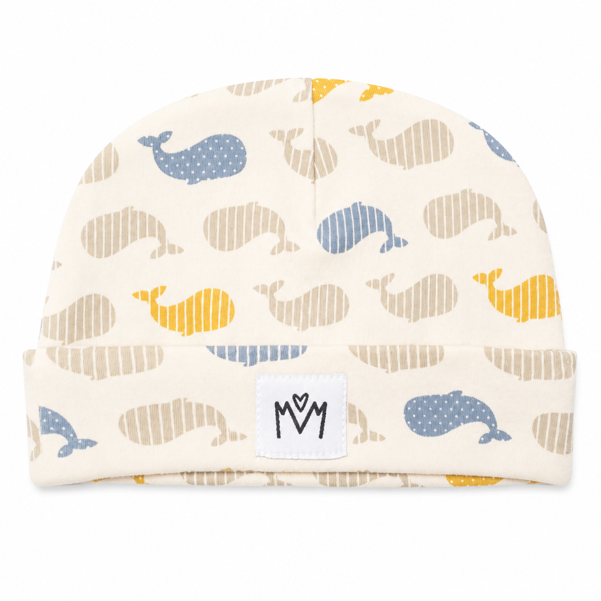 A baby knit beanie hat featuring an all-over whale print in blue, beige, and yellow on a cream background. The hat has a folded cuff with a white brand patch displaying a stylized 'M' logo.